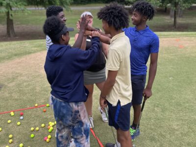 Group of 4 participants and a coach cheering after class.