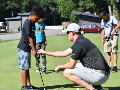 First Tee coach providing instruction.